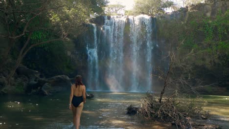 Slow-motion-gimbal-shot-of-woman-walking-into-stunning-Costa-Rican-waterfalls