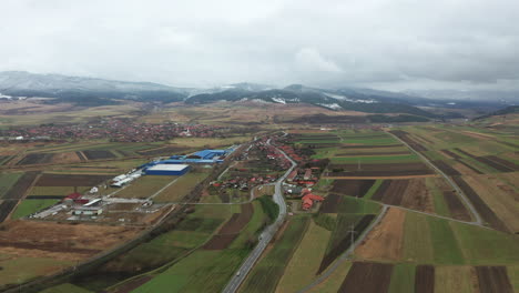 Aerial-push-in-towards-commune-of-Sancraieni,-cultivated-fields-in-Romania