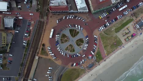 Birds-eye-drone-shot-of-Muizenberg,-Cape-Town---drone-is-ascending-over-the-famous-Surfers-Corner