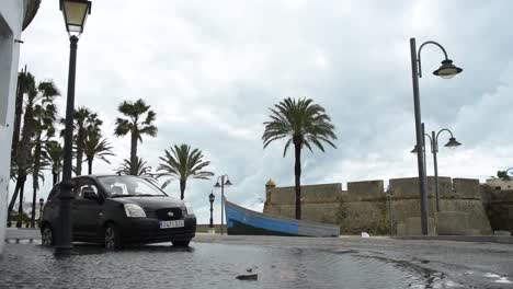 Car-parking-in-a-gigantic-puddle-after-heavy-rain-in-Cadiz,-Spain