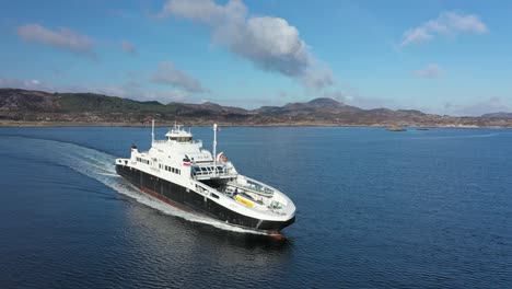 LNG-powered-car-and-passenger-ferry-Mastrafjord-from-Fjord1-company-underway-at-sea-between-Arsvagen-and-Mortavika---Aerial-following-ship-and-crossing-in-front-of-bow-in-sunny-weather