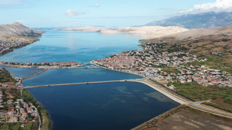 Vista-Aérea-Del-Mar-En-Calma-Con-La-Ciudad-Costera-En-La-Isla-De-Pag,-Croacia