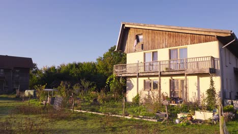 Ver-Edificio-En-Eco-Aldea-En-Sieben-Linden-Bañado-Por-La-Luz-Del-Sol-Con-Jardín-De-Hierbas-De-Plantas-Comestibles