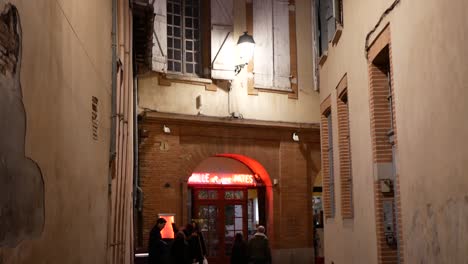Tilt-down-over-a-small-old-street-in-Toulouse-at-night