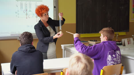 Profesora-Adulta-Presentando-Una-Lección-A-Un-Salón-De-Clases-Lleno-De-Jóvenes-Estudiantes-Varones-En-La-Escuela-Secundaria-Vocacional-En-Eslovaquia