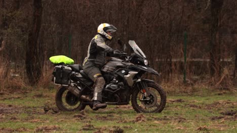 Heavy-motorcycle-stuck-in-the-mud-on-the-rainy-green-field,-adventurous-offroad-motorbike-driver-suffers-from-stalling-in-rainy-swampy-terrain-Slow-Motion
