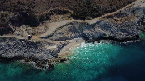 Bird-eye-view-drone-shot-of-Albanian-coast-in-the-Mediterranean-sea---drone-is-descending,-facing-a-lonely-beach