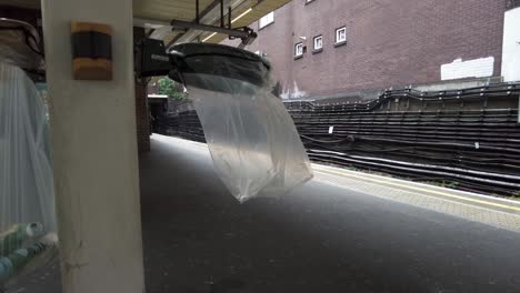 Leerer,-Durchsichtiger-Abfallbeutel,-Der-Am-12.-Mai-2022-Auf-Dem-Bahnsteig-Am-Bahnhof-Finchley-Road-In-London-Im-Wind-Weht