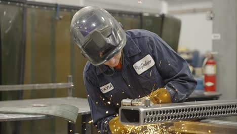 Slow-mo,-factory-blue-collar-worker-with-face-shield-up-welding-metal