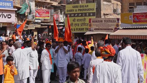 People-wave-the-saffron-flags-in-the-back-of-the-crowd-of-the-procession-of-Lord-Ram