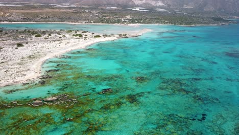 Vista-Aérea-De-Drones-De-Una-Hermosa-Playa-De-Arena-Y-Lagunas-Cristalinas-En-Elafonissi,-Creta,-Grecia