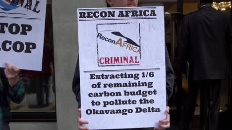 Un-Manifestante-Contra-El-Cambio-Climático-Sostiene-Un-Cartel-Que-Llama-&quot;criminal&quot;-A-La-Empresa-De-Energía-Recon-Africa-Fuera-Del-Hotel-Mayfair-Durante-La-Cumbre-De-Energías-De-áfrica