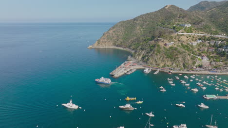 Toma-Aérea-De-Varios-Barcos-En-Aguas-Cristalinas-Del-Océano,-Perspectiva-De-Drones-De-Barcos-En-El-Puerto-Azul-Turquesa-En-La-Isla-Catalina