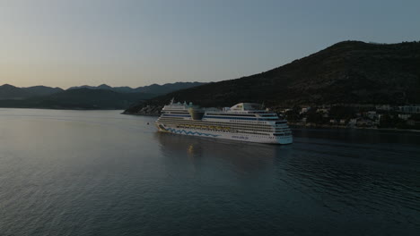 5-km-Luftdrohne-Des-Aidnova-Kreuzfahrtschiffs,-Das-Bei-Sonnenuntergang-Vom-Malerischen-Dubrovnik,-Kroatien,-Wegsegelt