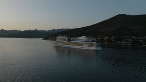 Drone-Aéreo-De-5k-Del-Crucero-Aidnova-Navegando-Lejos-Del-Pintoresco-Dubrovnik,-Croacia-Al-Atardecer