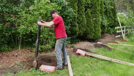 Man-use-post-hold-digger-to-clear-out-a-hole-for-a-fence-post