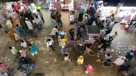 Busy-food-market-at-night,-People-crossing-the-street-market-with-food-stalls,-Directly-above-shot