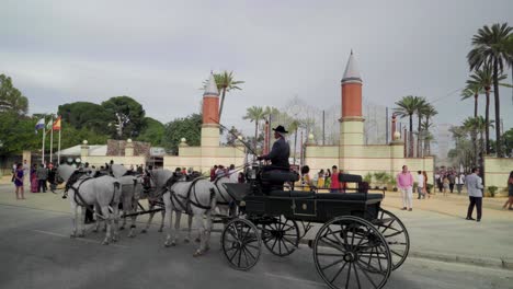 Kutsche-Mit-Kutscher-Und-Vier-Weißen-Pferden-Vor-Den-Toren-Der-Messe,-Jerez,-Spanien