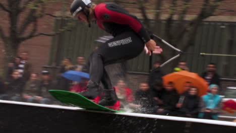 Super-slow-motion-of-a-Wakeboarder-sliding-a-box-in-a-pond-while-holding-on-to-a-winch