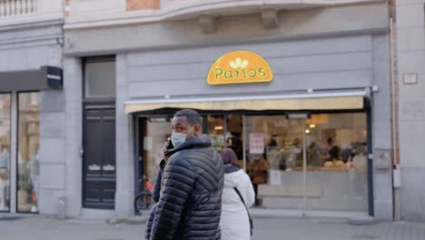 People-line-up-outside-sandwich-bar-Panos-in-Leuven,-Belgium