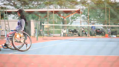 Yogyakarta,-Indonesien---2.-Mai-2021:-Verschleierte-Asiatin-Im-Rollstuhl,-Die-Auf-Dem-Platz-Tennis-Spielt