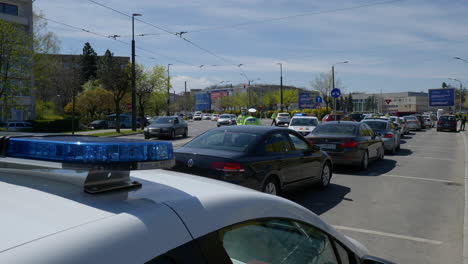 Wide-shot-with-detail-of-police-flashing-lights-behind-a-long-queue-of-cars-at-the-the-second-drive-through-COVID-19-vaccination-center-in-Romania