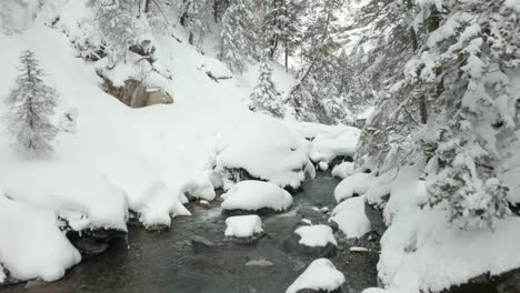 Moving-over-small-stream-in-snow-covered-landscape