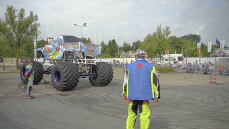 Die-Leute-Schauen-Auf-Einen-Monstertruck-Mit-Riesigen-Rädern,-Der-Durch-Die-Arena-Fährt