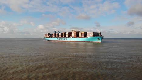 Partly-loaded-giant-containervessel-loaded-and-lashed-with-containers-on-deck-heading-on-a-calm-northsea-towards-the-Port-of-Rotterdam-on-a-partly-cloudy-day