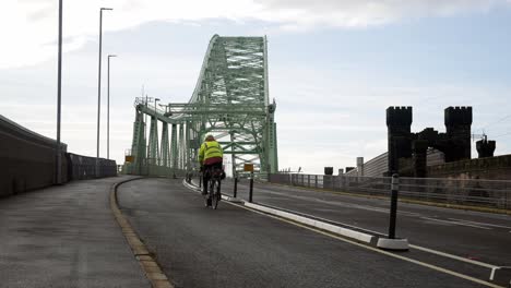 Cyclist-commuting-to-work-over-closed-Runcorn-Silver-Jubilee-bridge-crossing-road-during-corona-virus-pandemic