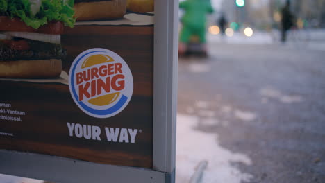 Close-up-slomo-of-Burger-King-sign-in-winter,-people-in-background