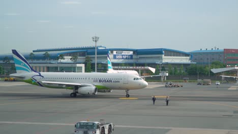 Avión-Estacionado-En-La-Pista-Frente-Al-Edificio-En-El-Aeropuerto-De-Busan-En-Corea-Del-Sur