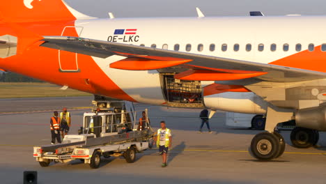 Baggage-Handlers-And-Truck-mounted-Conveyor-At-Work-In-Milan-Bergamo-Airport-In-Italy