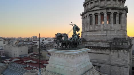 Aerial-pan-right-of-a-bronze-quadriga-monument-in-front-of-Angrentine-Congress-Palace-Dome-at-golden-hour,-Buenos-Aires