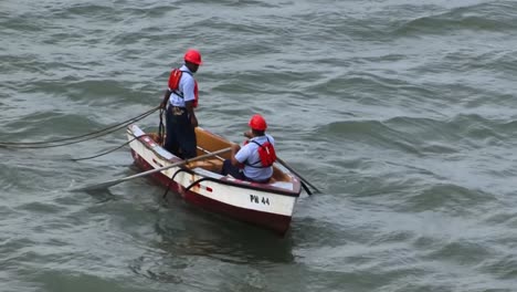 Panamakanalarbeiter-Bringen-Die-Festmacherleinen-In-Einem-Kleinen-Ruderboot