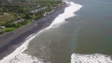 Aerial-View-of-Black-Sand-Beach-and-Ocean-Waves-on-Coastline-of-Bali,-Indonesia