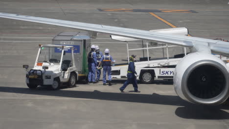 Baggage-Handlers-Unloading-Luggage-From-An-Airplane-Through-Conveyor-System-At-The-Airport