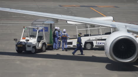 Gepäckabfertiger-Entladen-Gepäck-Aus-Einem-Flugzeug-über-Ein-Förderbandsystem-Am-Flughafen