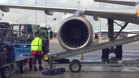 Footage-of-airport-baggage-handler-ramp-agent-loading-the-baggages,-luggages-and-suitcases-with-the-help-of-baggage-conveyor-belt-loader