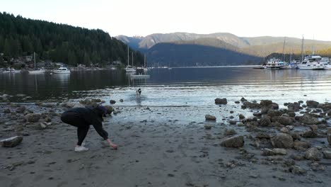 Playing-with-a-dog-on-the-beach-in-deep-cove,-British-Columbia