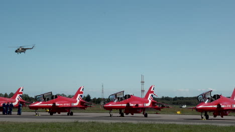 Hubschrauber-Fliegt-über-Kampfflugzeuge-Der-Raf-Red-Arrows-Auf-Dem-Flugplatz-In-Gdynia,-Polen