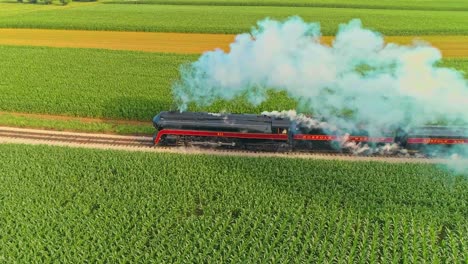 Paisaje-Aéreo-De-Tierras-De-Cultivo-Y-Un-Antiguo-Motor-De-Vapor-Que-Sopla-Mucho-Humo-Y-Parada-De-Vapor-Y-El-Dron-Mira-Directamente-Hacia-Abajo-En-Una-Mañana-De-Verano-Temprano