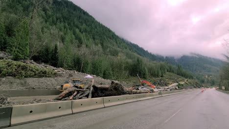 Heavy-equipment-clears-a-pile-of-dirt-and-rock-left-over-from-a-heavy-flood-on-the-side-of-a-road-in-Popkum-city,-British-Columbia-province,-Canada-on-November-23,-2021