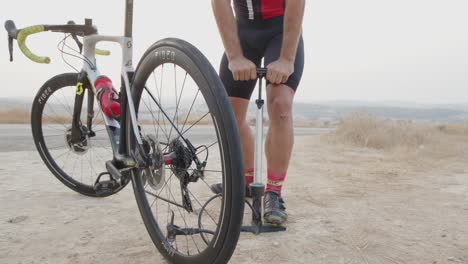 Zeitlupe-Eines-Professionellen-Radfahrers,-Der-Mit-Einem-Handlot-Luft-In-Seine-Reifen-Füllt