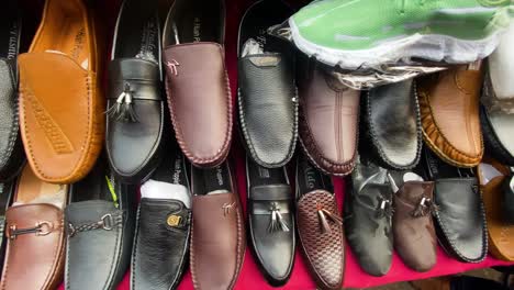 Slow-Pan-Right-Across-Rack-Of-Formal-Shoes-At-Market-In-Mirpur,-Dhaka