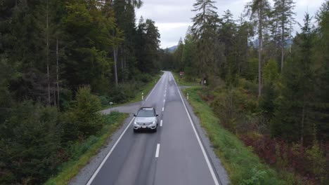 Luftaufnahme-Vor-Einem-Volvo-XC40-Auto-Auf-Einer-Forststraße---Zurückziehen,-Drohnenaufnahme