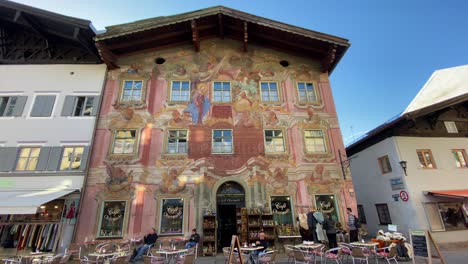 Historical-building-with-coffee-shop-and-colorful-wall-paintings,-located-at-the-Obermarkt-street-of-the-old-bavarian-town-of-Mittenwald-in-Germany