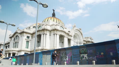 Giant-barriers-covered-in-graffiti-protect-the-Palacio-de-Bellas-Artes,-Palace-of-fine-arts-ahead-of-a-protest-in-Mexico-City