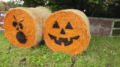 Countryside-orange-Halloween-pumpkin-face-hay-bale-marketing-promotion-on-rural-farmland