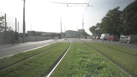 Crossing-public-tramway-tracks-with-people-passing-walking-and-riding-bicycle,-Dolly-right-slow-motion-shot